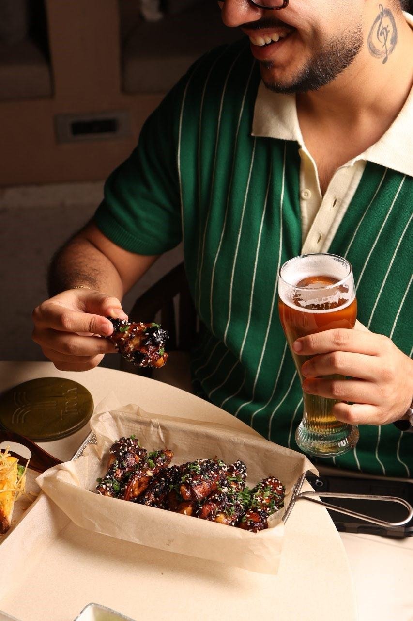 Guest enjoying craft beer and wings at TBC beer pub