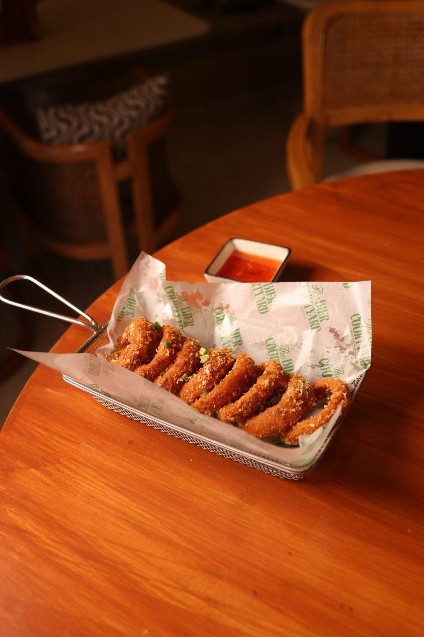 Crispy onion rings basket with beer at a pub in Pune